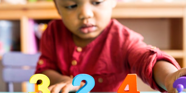 young child playing with number blocks